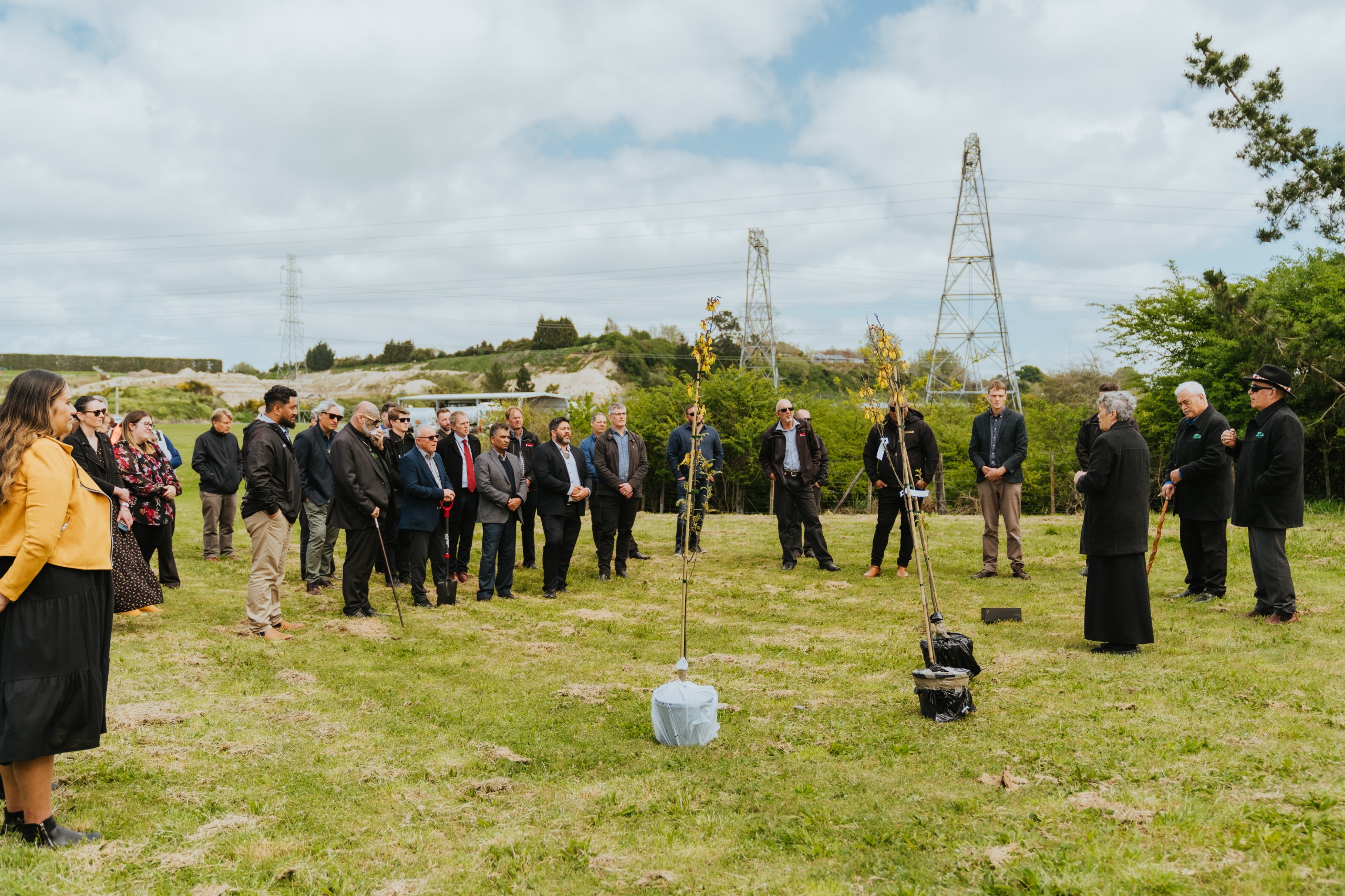 group gathered outside to bless the site and plant two kowhai trees