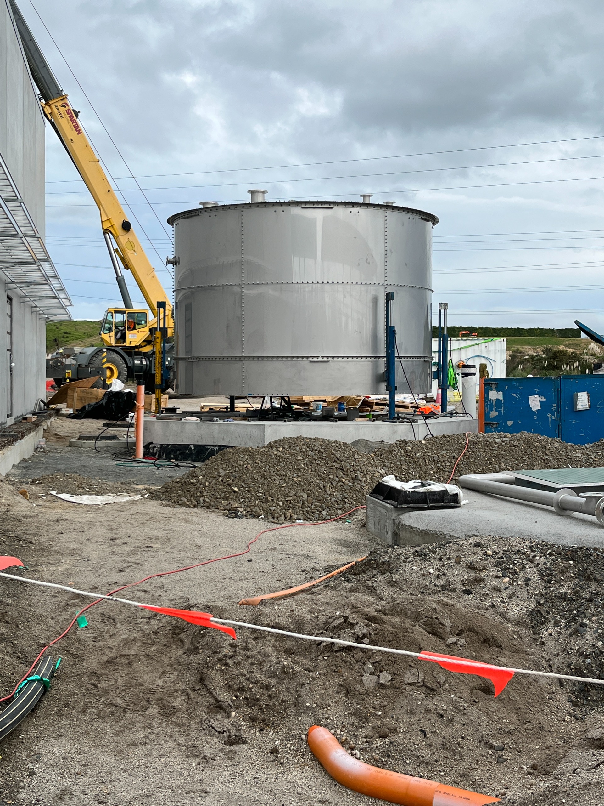 very large stainless steel tank with a crane in the background