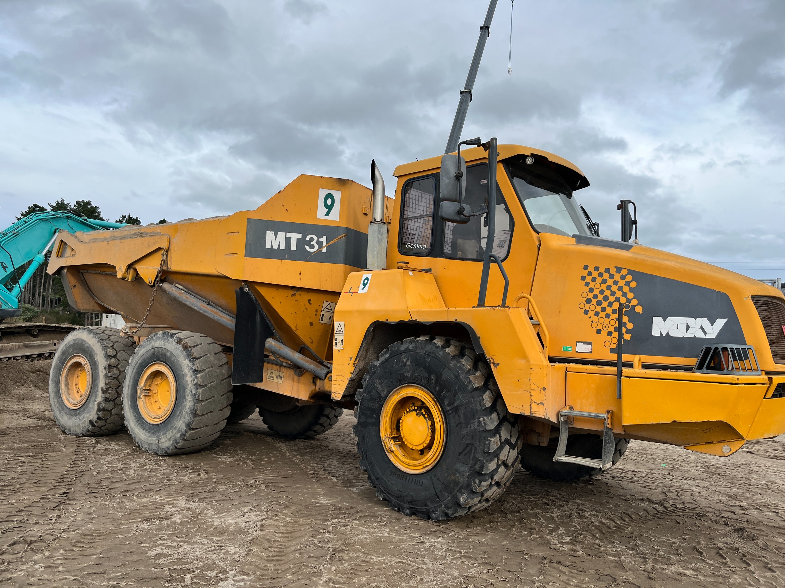 Large yellow dump truck with the name Gemma painted in the side